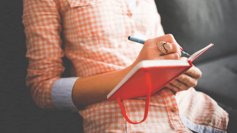 Femme avec un carnet de note dans les mains