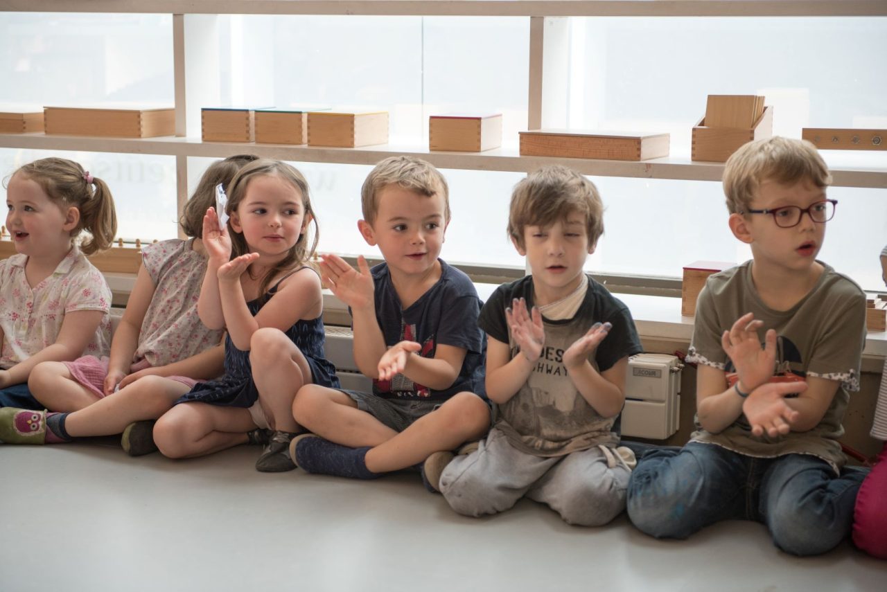 Enfant partageant un sourire au tableau en école Montessori à Issy