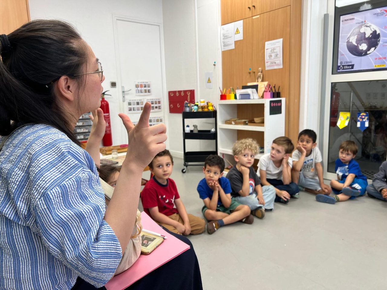 Enfants assis en cercle sur le tapis de la classe