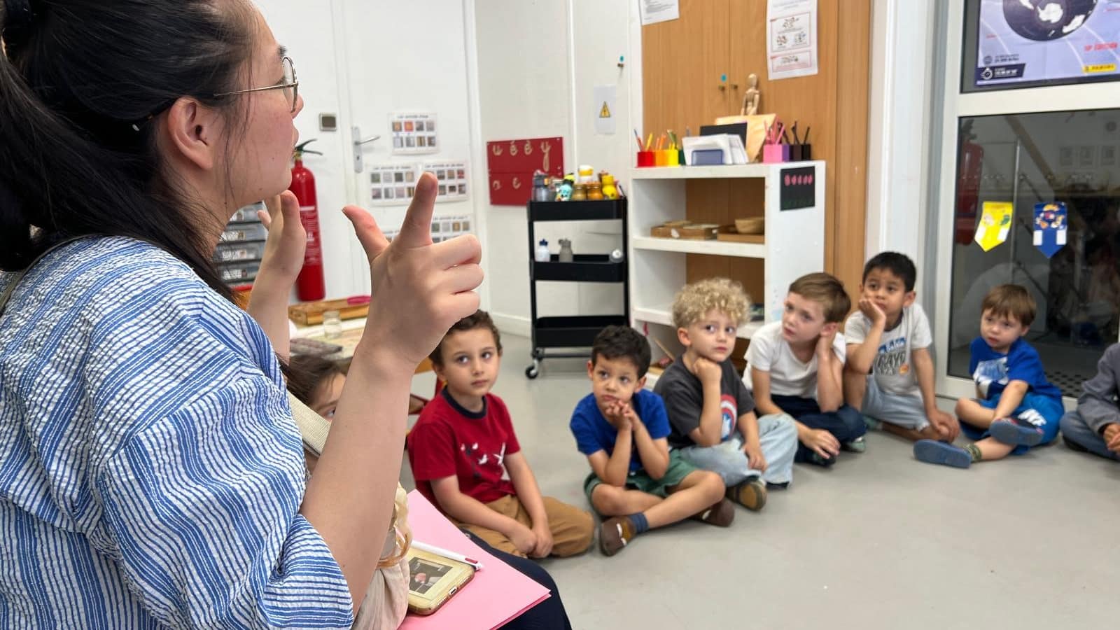 Enfants assis en cercle sur le tapis de la classe